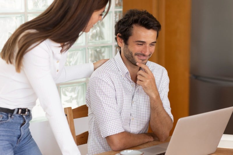 Couple reviewing short-term loan application process on laptop at home