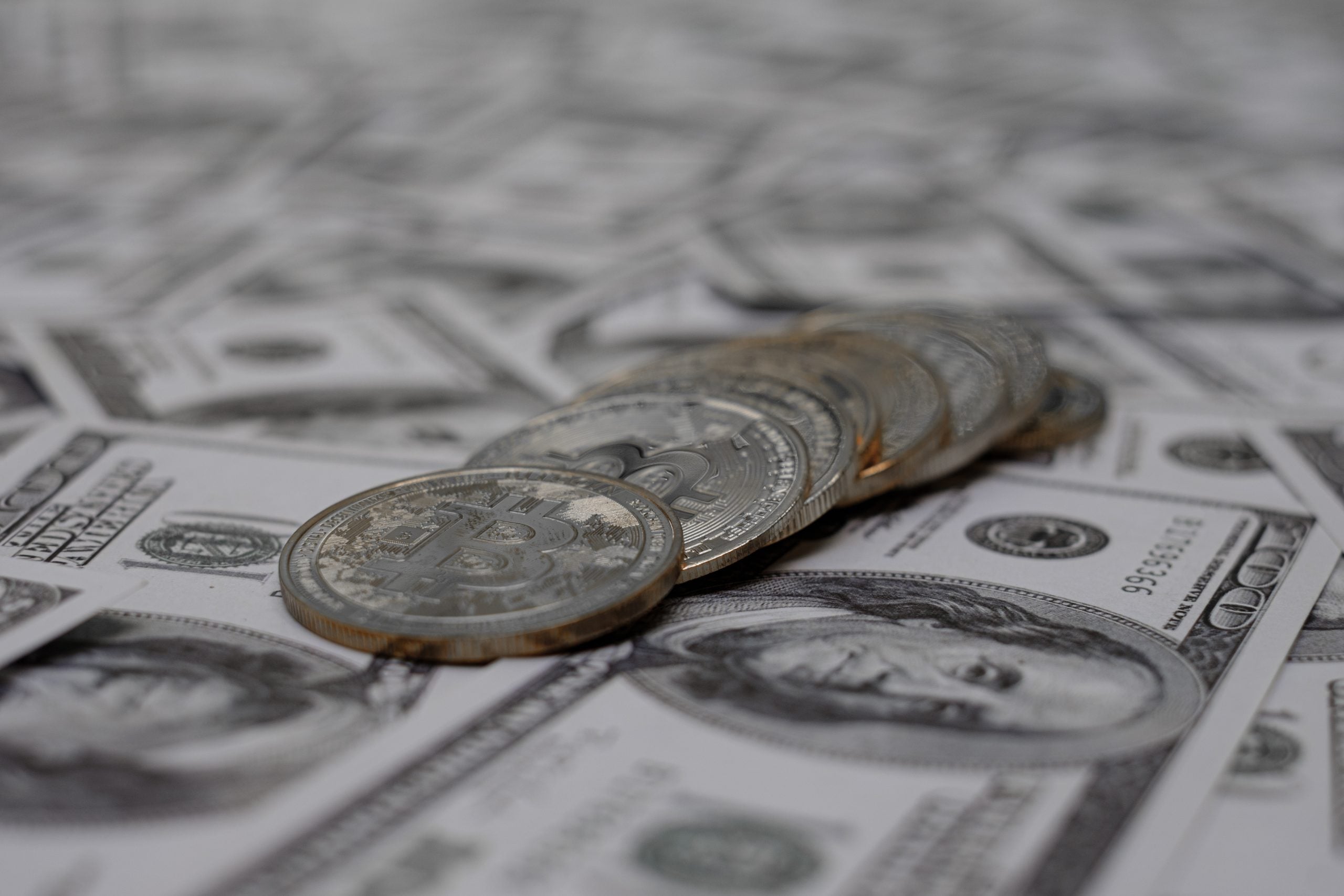 Pieces of US paper money spread across a white background in a close-up shot.